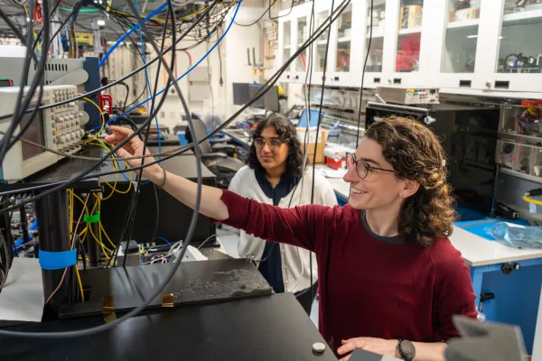 Two female presenting students in quantum engineering lab